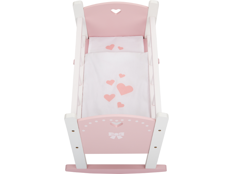 Roze en witte poppenwieg met hartjes en strikmotief.