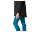 Vrouw in zwarte jas en turquoise legging.