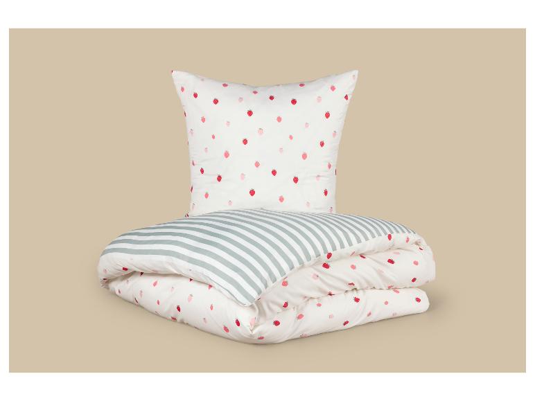 Beddengoedset met aardbeien en strepen, opgevouwen op een beige achtergrond.