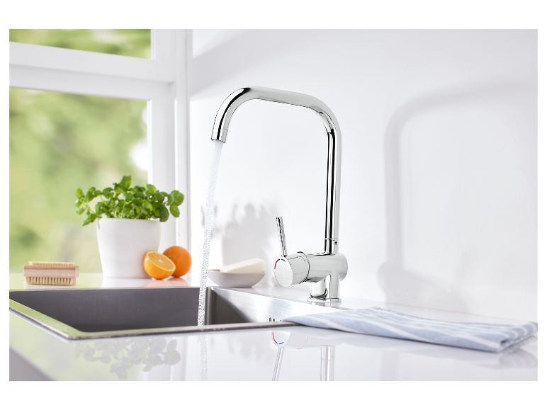 Moderne minimalistische keukenkran met stromend water.