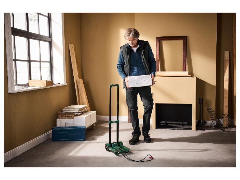 Man met pakket, met opvouwbare trolley en bouwmaterialen in de buurt.