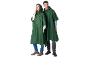 Twee mensen in donkergroene regenponcho's met capuchon, jeans en laarzen.