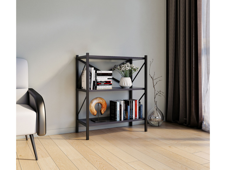 Een zwarte boekenkast met boeken, sculpturen en bloemen.