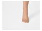 Voet in beige panty tegen een witte achtergrond.