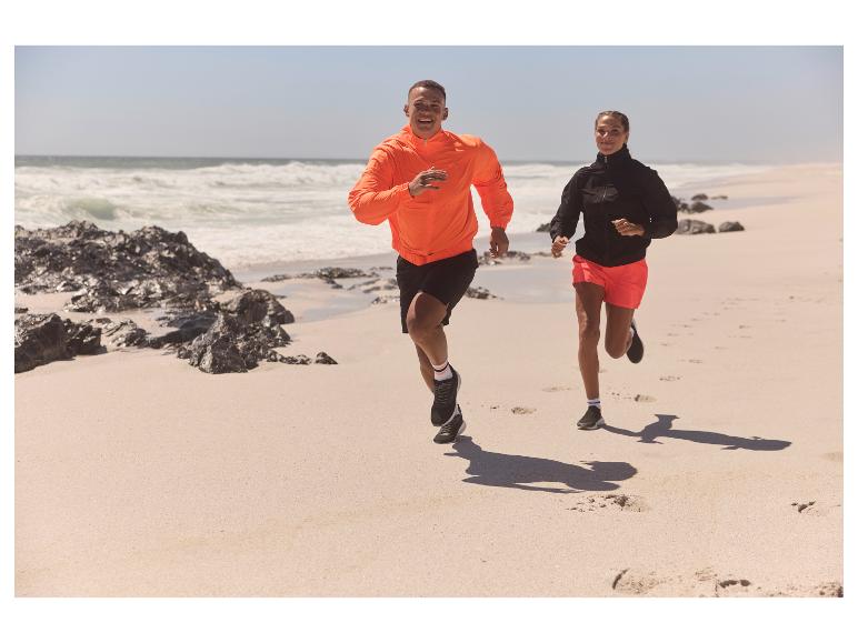 Koppel rent op het strand in sportkleding.