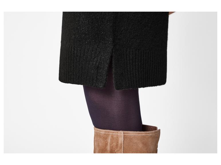 Zwarte gebreide rok met zijsplit, paarse panty en bruine suède laarzen.