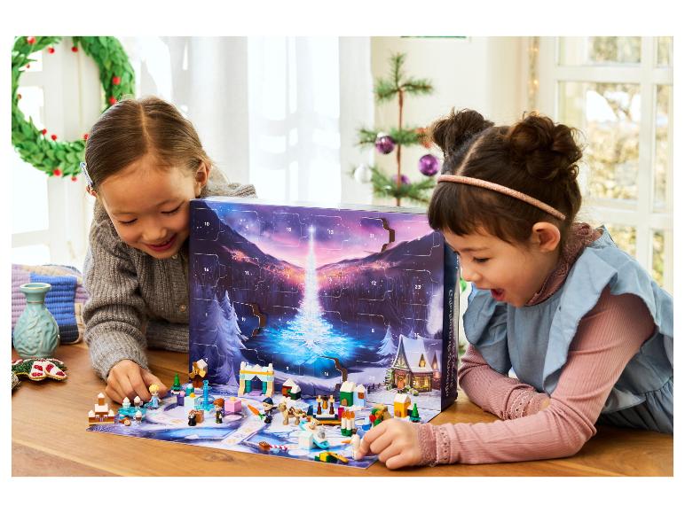 Twee meisjes spelen met een LEGO Disney Frozen adventskalender, met figuren en accessoires.