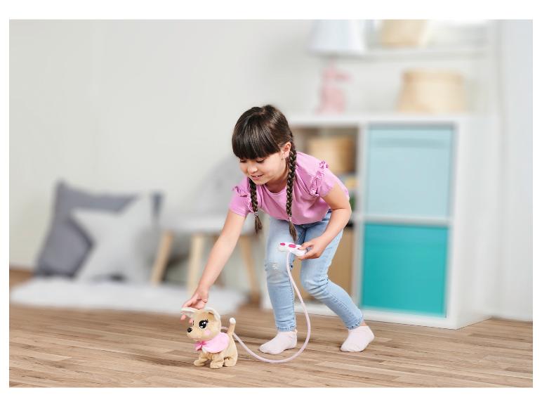 Een meisje speelt met een interactief, op afstand bestuurd knuffelhondje.