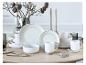 Wit en grijs servies op een houten tafel, met herfstdecoraties en kaarsen.