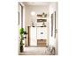 Halmeubel met schoenenkast, planken en spiegel in wit en hout, met planten en decoratie.