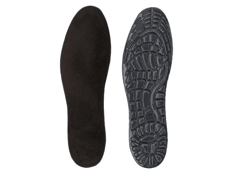 Twee zwarte schoenzolen, één glad en één met profiel, op een witte achtergrond.