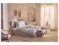 Slaapkamer met tweepersoonsbed, blauw-beige geruit beddengoed en rieten wanddecoraties.