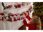 Meisje rangschikt een adventskalender op de schoorsteenmantel, met kerstdecoraties.