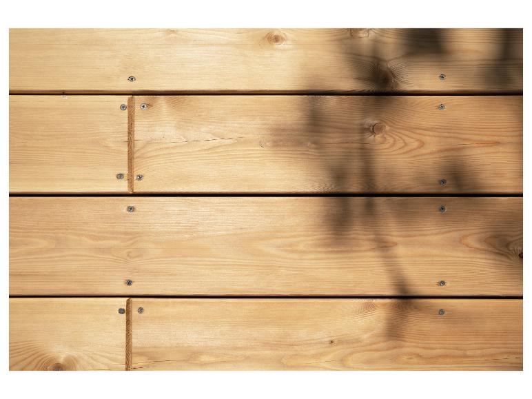 Houten achtergrond met lichte grenen planken en bladschaduwen