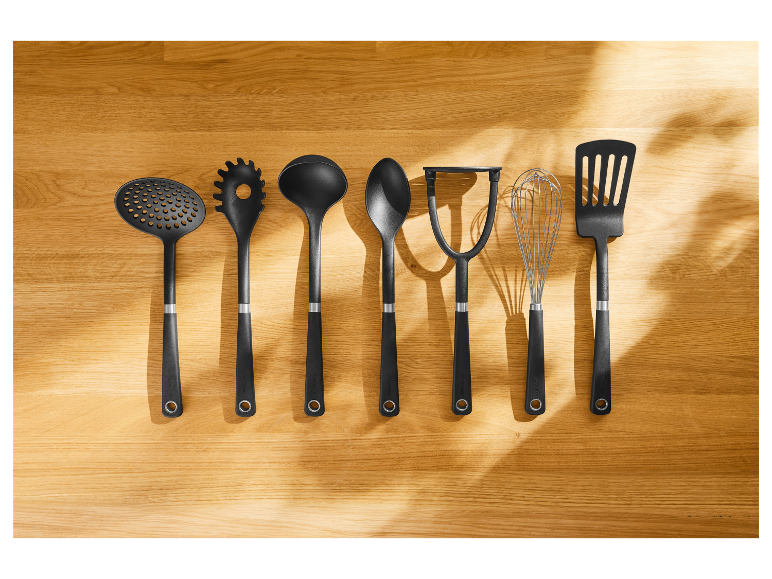 Zeven zwarte Zwilling J.A. Henckels keukengerei op een houten oppervlak.