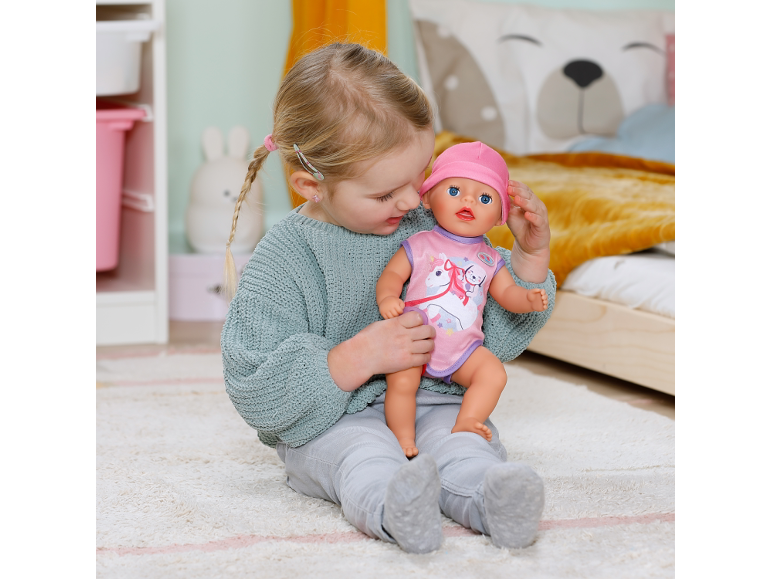 Klein meisje speelt met een pop in een kinderkamer.