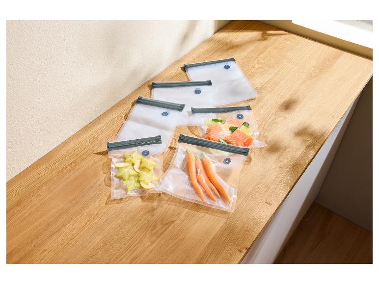 Vacuümzakken met stervrucht, wortels en zalm op een houten aanrecht.