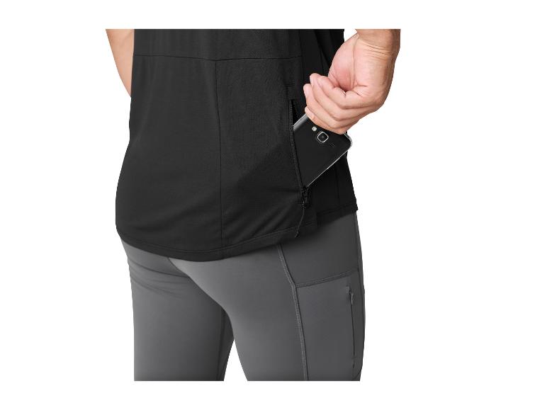 Man in zwart T-shirt en grijze broek, stopt telefoon in zijzak met rits.