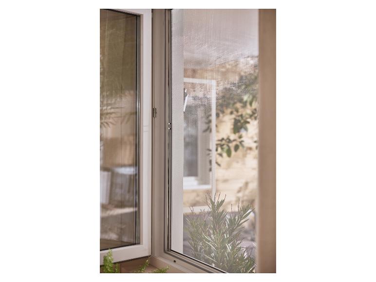 Open raam met hor, uitzicht op groen buiten.