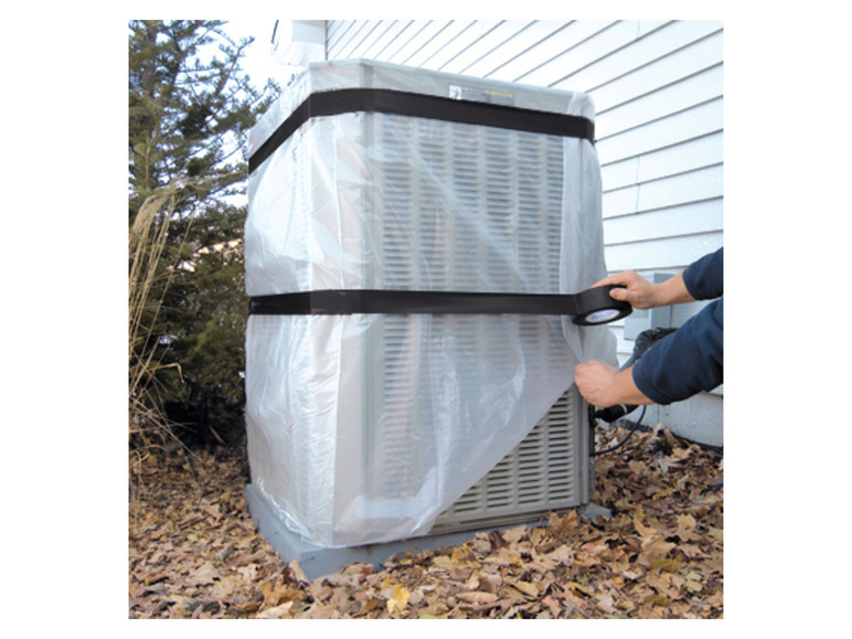 Een persoon die een airconditioningsysteem bedekt met plastic folie en tape.