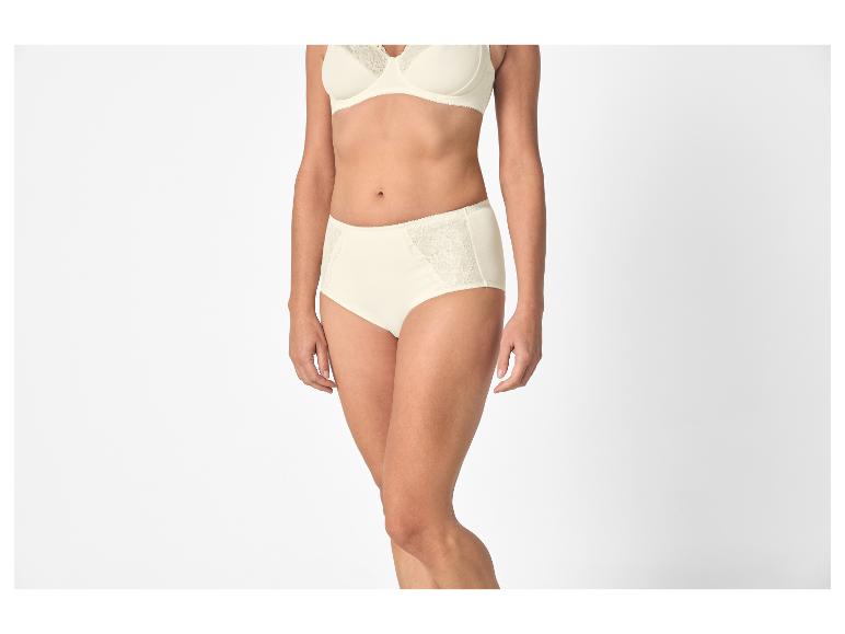 Vrouw in crèmekleurige kanten beha en bijpassende hoge slip.