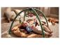 Baby speelt op een speelkleed met hangend speelgoed in een gezellige omgeving.