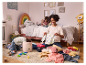 Een moeder sorteert kleding in een kinderkamer met regenboogthema.