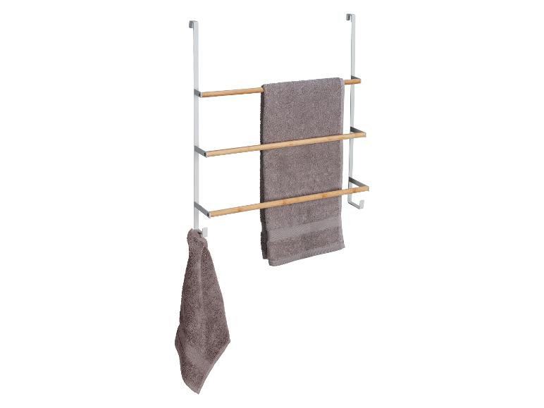 Een handdoekrek met drie houten latten en handdoeken.