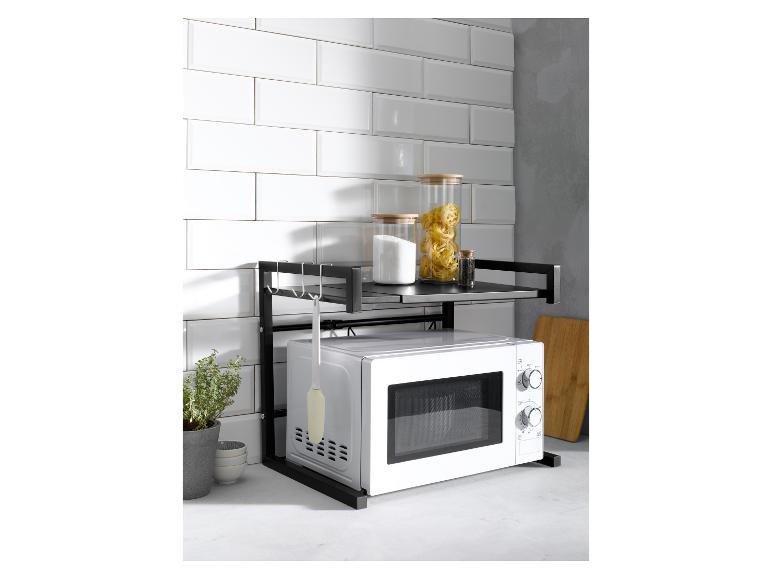 Magnetron en zwart keukenrek met opbergruimte; glazen potten.