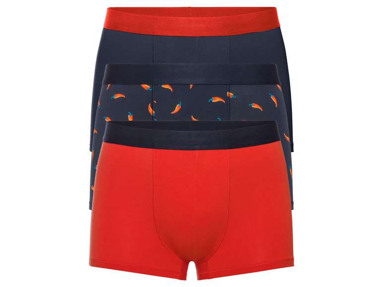 Drie boxershorts: één effen rood, één effen donkerblauw en één donkerblauw met pepers.
