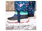 Een close-up van zwarte winterschoenen met een bloemenprint op de broekspijpen.