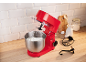 Rode keukenmixer met garde in een kom slagroom, op een aanrecht.