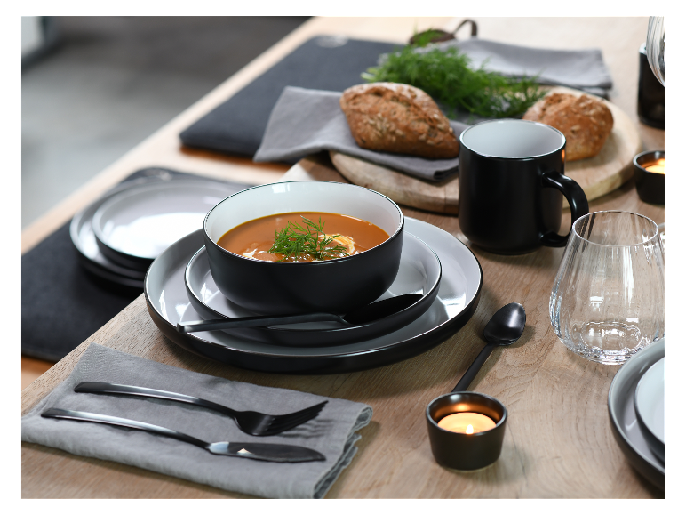Chique zwarte servies: schaal, borden en mok, met soep en brood.