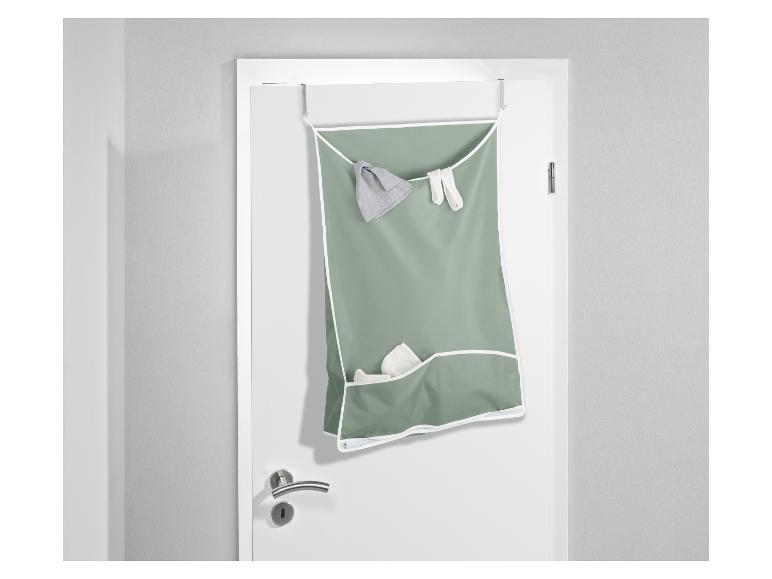 Een groene opbergzak met vakken, opgehangen aan een deur.