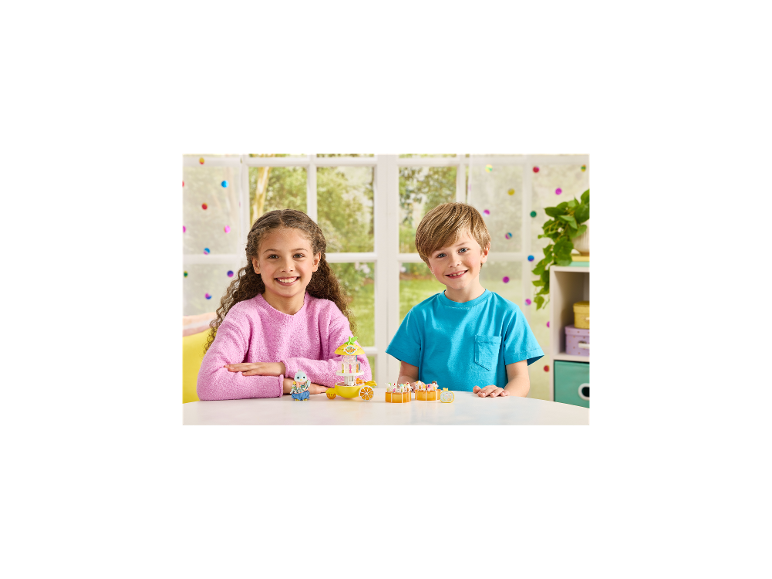Twee kinderen spelen met een speelgoedvoedselkar en miniatuur dierenfiguren op een witte tafel.