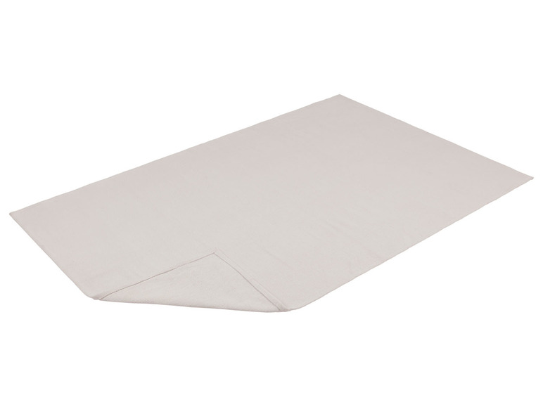 Een witte badhanddoek gevouwen op een witte achtergrond.