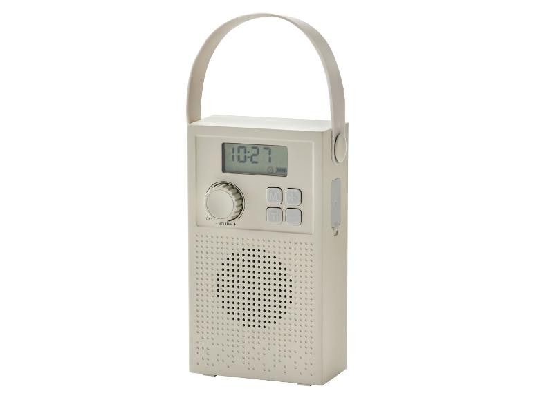 Draagbare beige radio met digitaal display, knoppen en handvat.