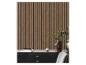 Houten lattenwandpaneel met een zwart bureau en decoratieve items.