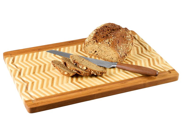 Gesneden meergranenbrood, mes en bamboe snijplank.