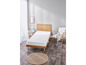 Een wit matras op een houten bedframe in een slaapkamer.