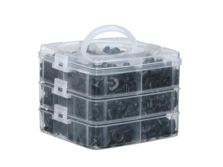 Doorzichtige drielaagse opbergdoos gevuld met zwarte autoklemmen.