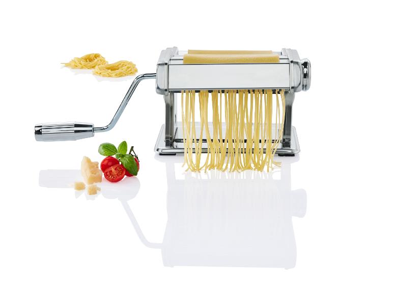 Pastamachine maakt spaghetti, met parmezaanse kaas en tomaten.