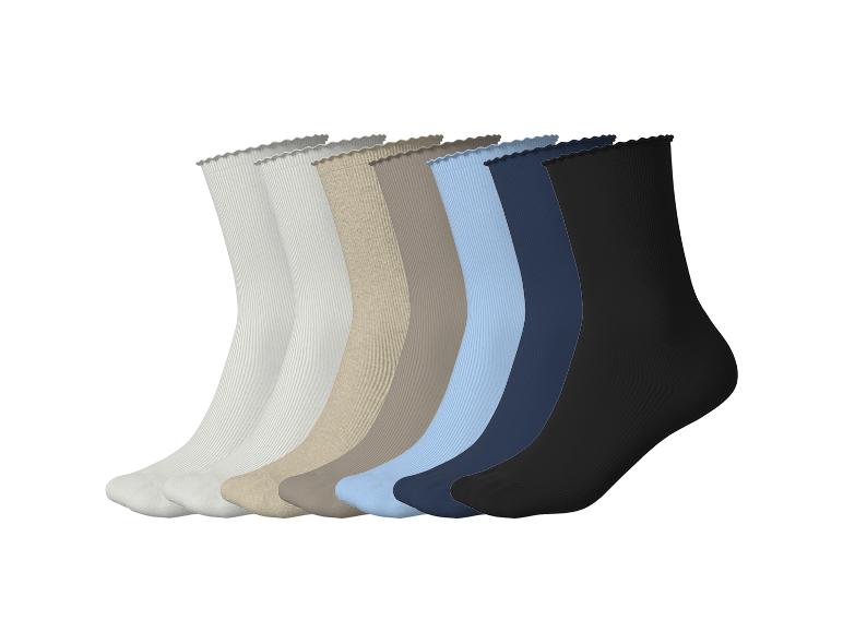 Zeven paar geribbelde sokken in diverse kleuren: wit, beige, bruin, lichtblauw, donkerblauw en zwart.