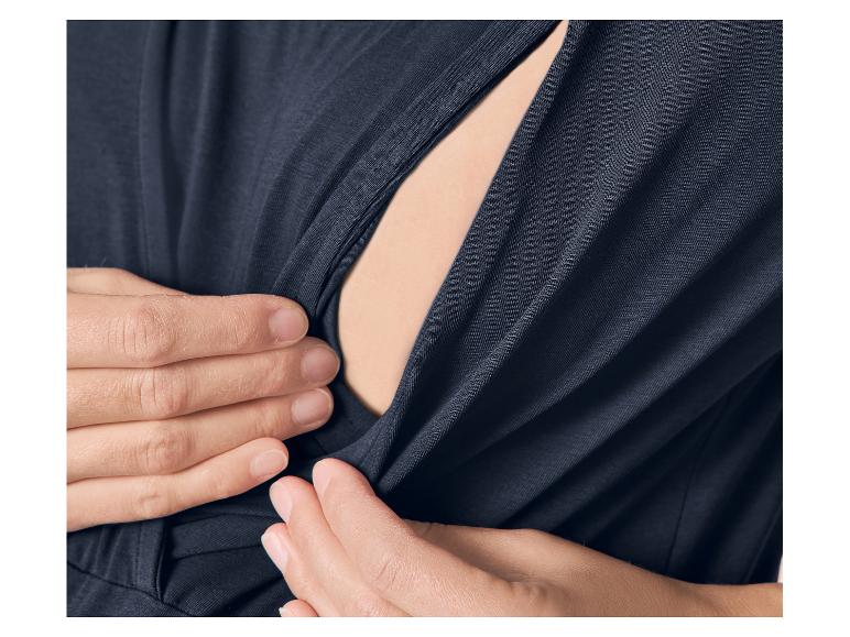 Close-up van handen die een donkerblauwe zwangerschapstop openen voor borstvoeding.