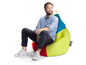 Een man zit op een limegroene, blauwe en rode beanbag van het merk Sitting Point.