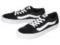 Paar zwarte lage sneakers met witte veters en zijstrepen