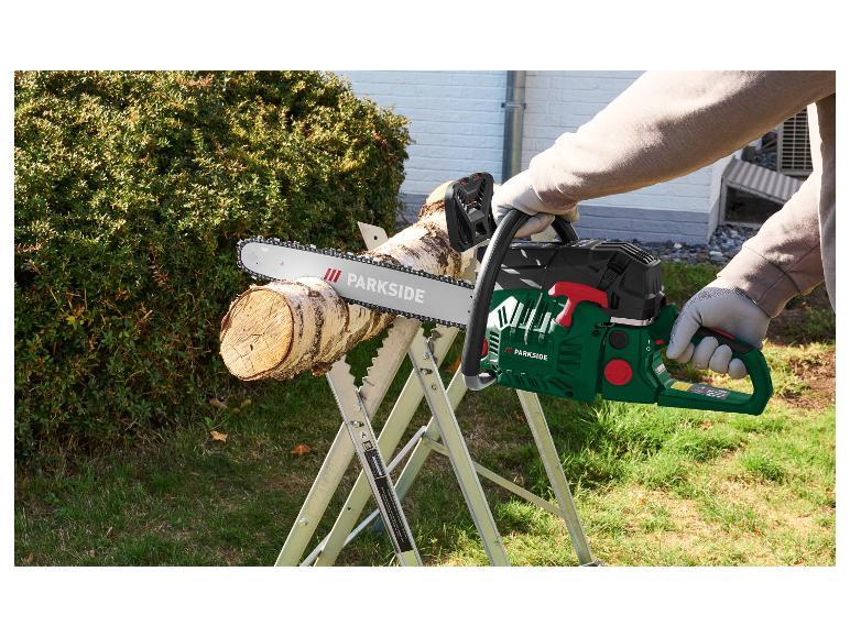 Man in handschoenen zaagt hout met een kettingzaag op een zaagbok.