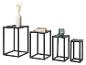 Set van vier zwarte metalen bijzettafels van verschillende hoogtes met decoratieve items.