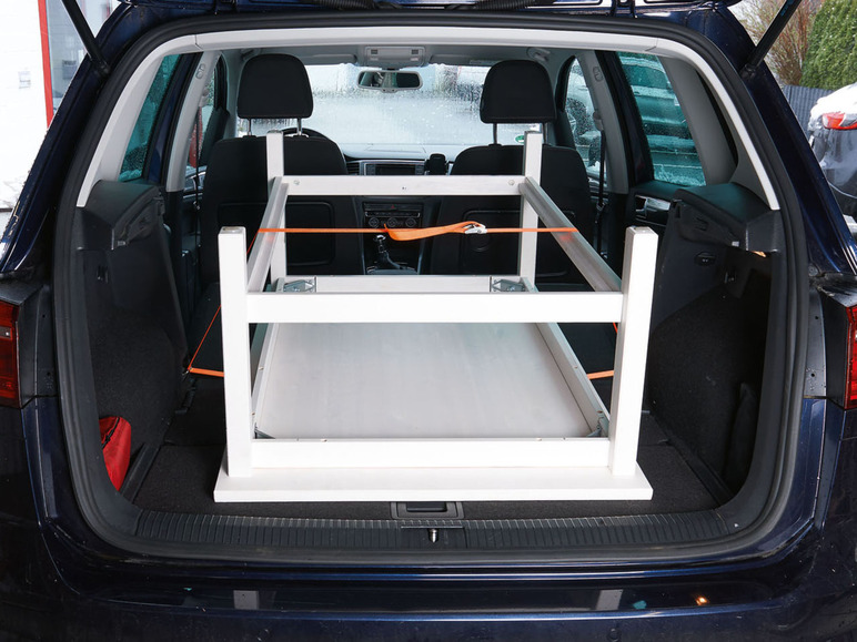 Een witte tafel in de kofferbak van een auto.