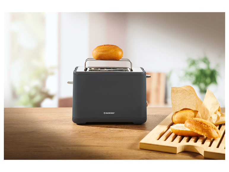 Een grijze SilverCrest broodrooster met broodjes op een houten oppervlak.